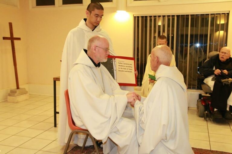 A monk kneels before his abbot and makes his vows