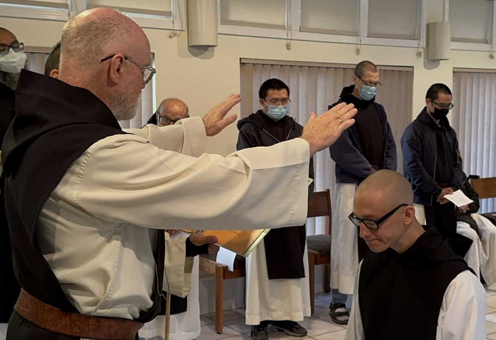 Dom Paul Mark extends hands in prayer over Brother Isaac at his first profession of vows